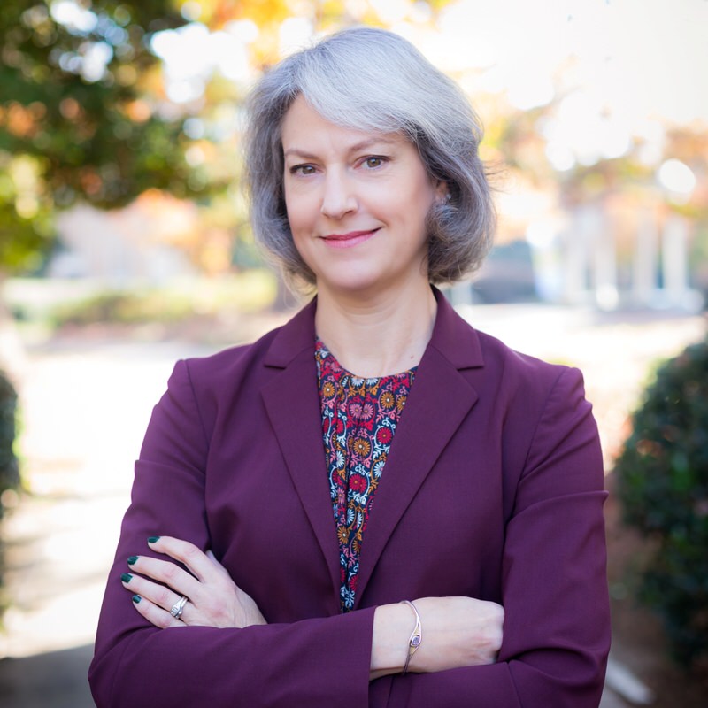 Child Welfare Law Specialist Deana Fleming smiles for a headshot in the UNC Garden in Chapel Hill.